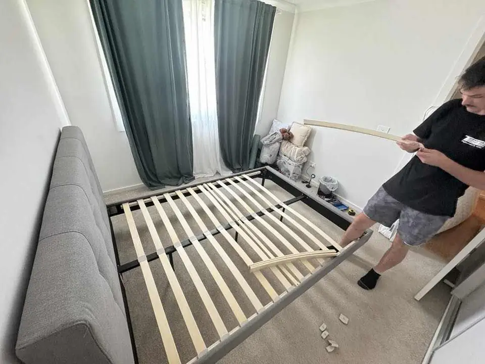 Bed frame being assembled in a bedroom