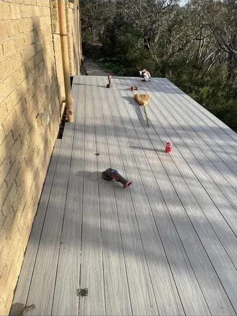 Long composite balcony deck beside a brick wall