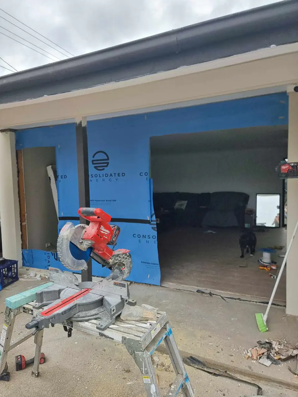 Wall framing with building wrap and a mitre saw set up