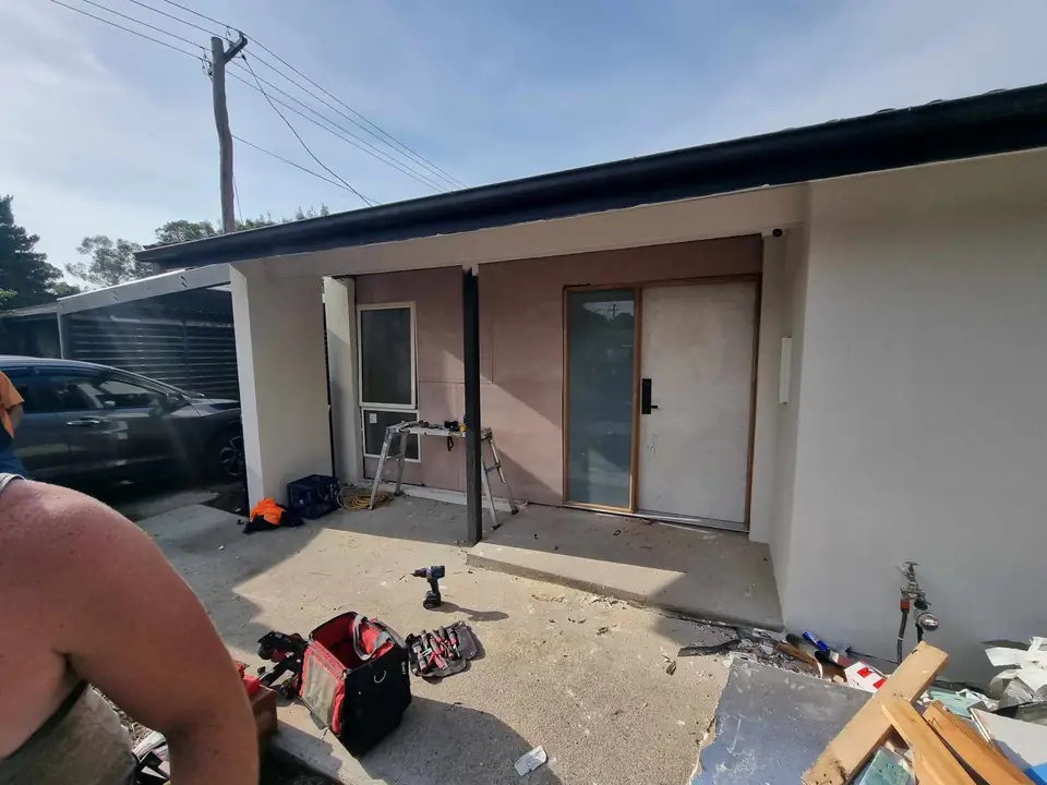 Newly framed and rendered front wall with entry door