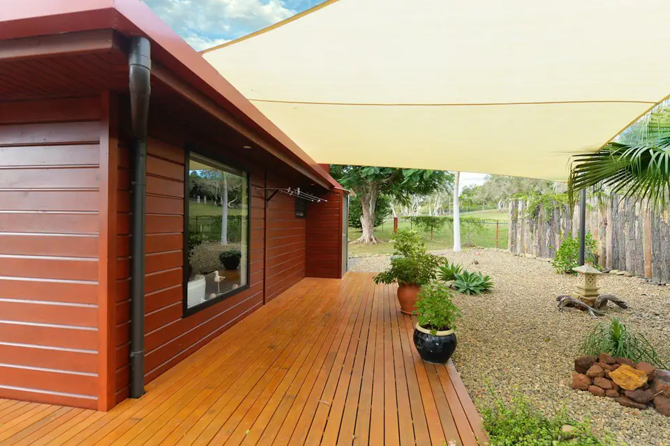 Timber deck along a house with a shade sail