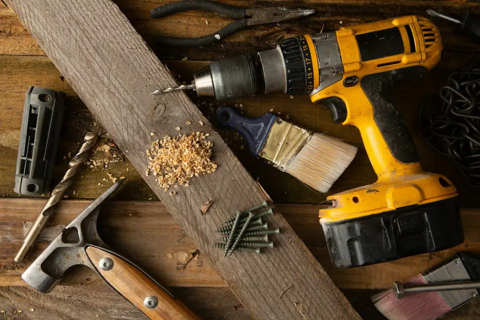 Hand tools, a cordless drill and timber offcuts on a workbench