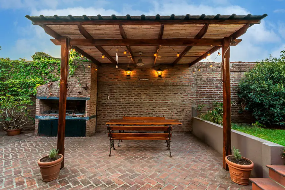 Timber pergola over a brick courtyard