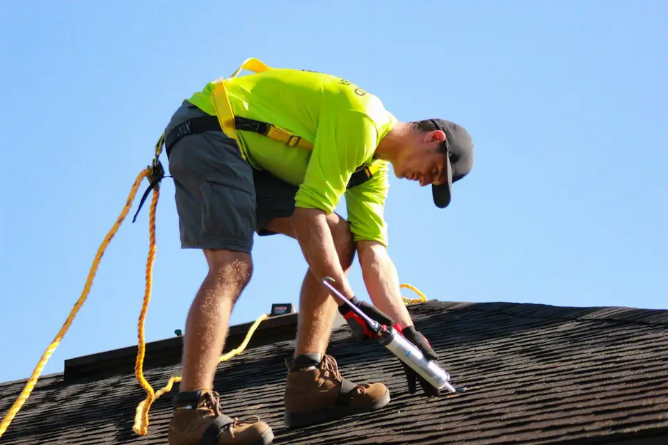 Roofer in hi-vis working on a roof