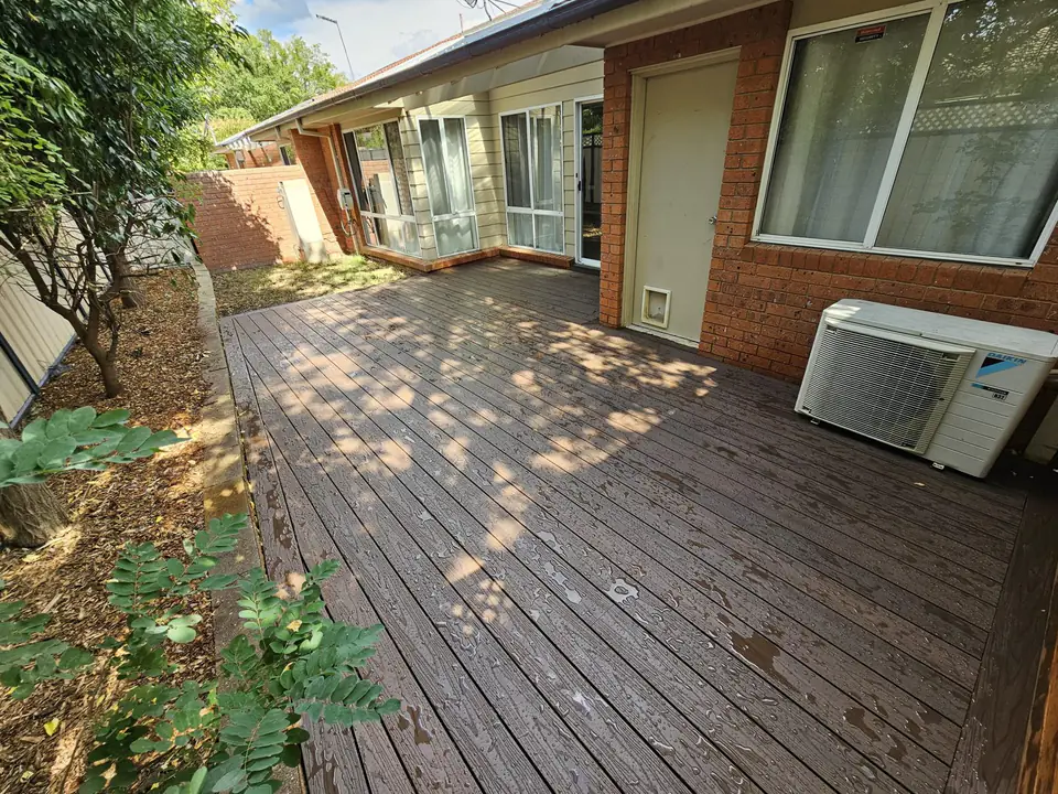 Timber deck along the back of a brick home