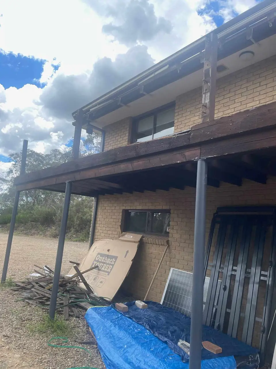 Upper level deck on the side of a brick home